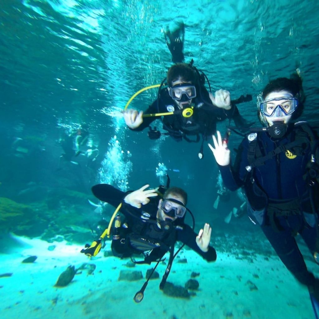 Three divers giving the OK sign during a cenote diving tour